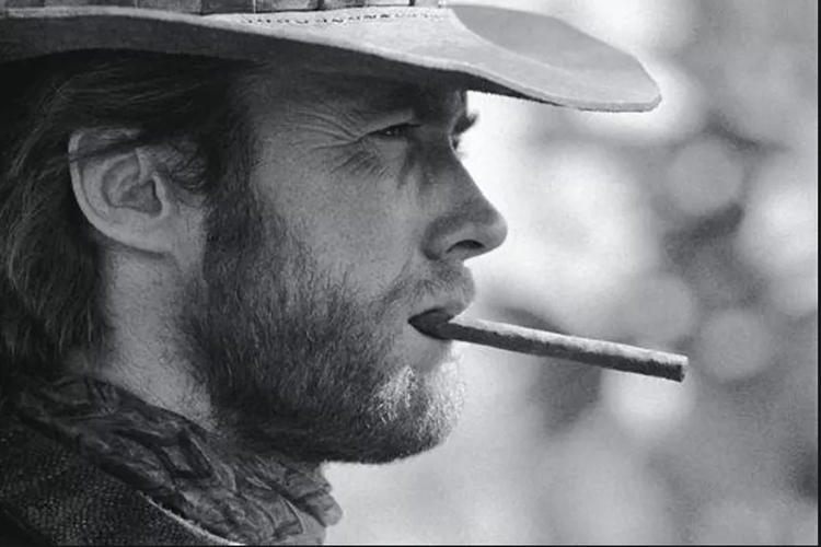 Clint Eastwood holding cigar in his mouth